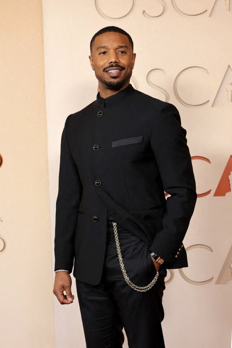 Michael B. Jordan, nominado a Mejor actor por Sinners, apostó por un tuxedo moderno de cuello mao de Louis Vuitton, acompañado por una cadena metálica y joyería discreta.  