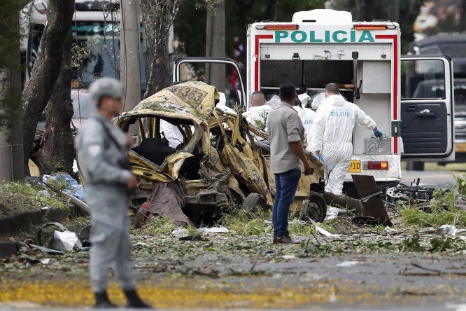 Integrantes de la Dirección de Investigación Criminal e Interpol (DIJIN) inspeccionan un vehículo afectado tras una explosión en inmediaciones de la Escuela Militar de Aviación Marco Fidel Suárez este jueves, en Cali (Colombia).&nbsp;
