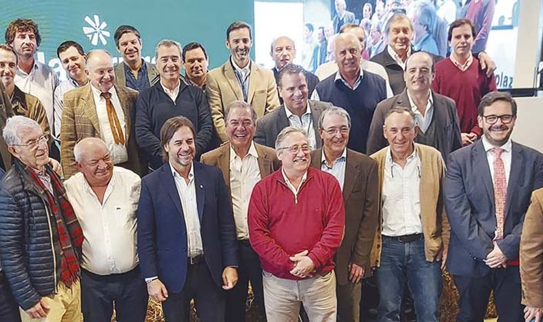 El presidente de la República, Luis Lacalle Pou, el ministro interino del Ministerio de Ganadería, Agricultura y Pesca (MGAP), Ignacio Buffa, el presidente del Banco República, Salvador Ferrer, y el presidente del Instituto Nacional de Carnes, Conrado Ferber, con los socios de Plaza Rural