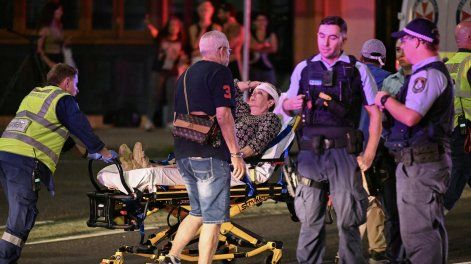 Los trabajadores de la salud trasladan a una mujer en una camilla a una ambulancia después de un tiroteo en Bondi Beach en Sydney el 14 de diciembre de 2025.