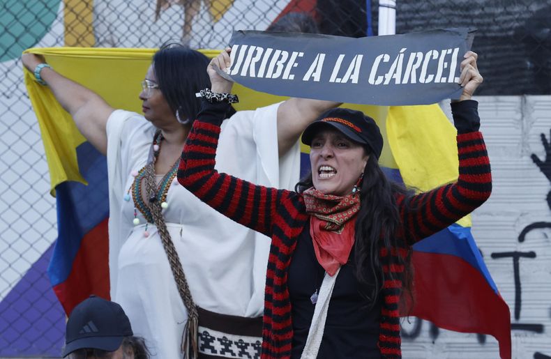Una detractora del expresidente de Colombia, Álvaro Uribe, sostiene un cartel frente al Complejo Judicial de Paloquemao este lunes, en Bogotá (Colombia)