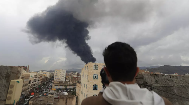 Un fotoperiodista toma una foto de la columna de humo tras un ataque aéreo israelí contra Saná, la capital de Yemen controlada por los hutíes, el 24 de agosto de 2025.