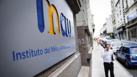 Una persona pasa por frente a la sede del INAU. Foto: Javier Calvelo / adhocFOTOS