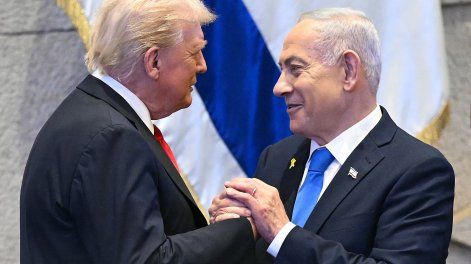 El presidente de Estados Unidos, Donald Trump (izq.), se toma de la mano y habla con el primer ministro israelí, Benjamin Netanyahu, en el parlamento israelí, la Knéset, en Jerusalén, el 13 de octubre de 2025.