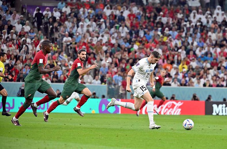 El uruguayo Federico Valverde marcado por los futbolistas de Portugal William y Rubén Neves durante un partido de la Copa Mundial 2022. Foto: AUF.org.uy
