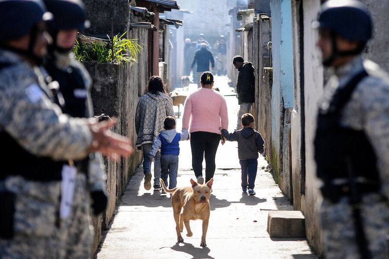 Una mujer camina con sus hijos en el complejo de la Unidad Misiones, conocido como Los Palomares de Casavalle, Montevideo. Foto: Javier Calvelo/ adhocFOTOS