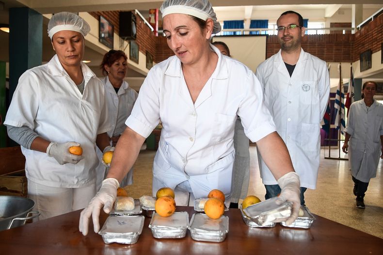 Reparto de bandejas de almuerzo en la Escuela N° 326 de tiempo completo del barrio Casavalle de Montevideo
