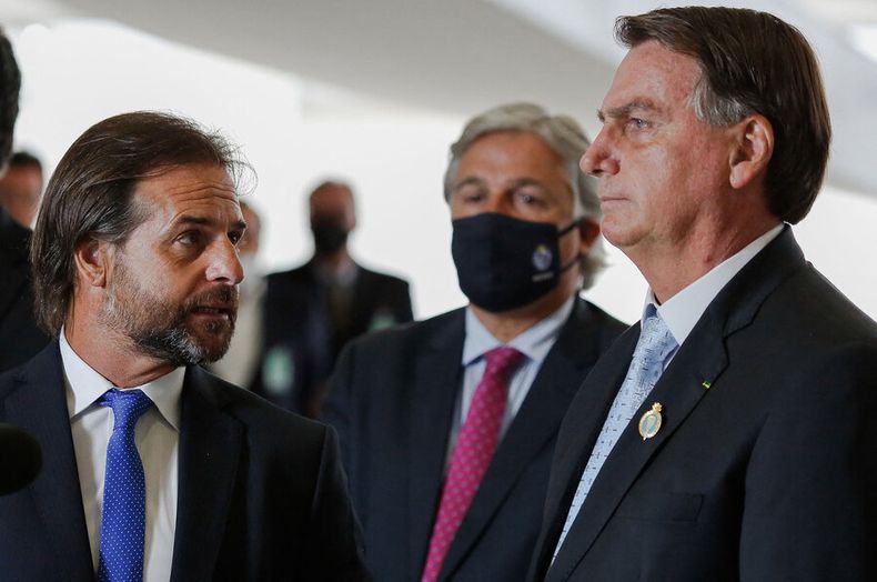 Luis Lacalle Pou habla con Jair Bolsonaro, ante la mirada del canciller Francisco Bustillo. Foto: AFP.
