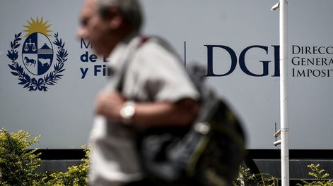 Una persona camina frente a la sede de la DGI en Montevideo. Foto: Javier Calvelo / adhocFOTOS