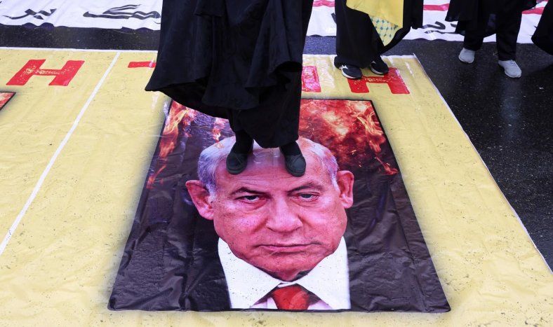 Ciudadanos iraníes pisotean un cartel con la imagen del primer ministro israelí, Benjamin Netanyahu, durante una manifestación para conmemorar el Día Internacional de Al-Quds en Teherán, Irán, el 13 de marzo de 2026.&nbsp;