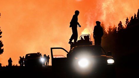 Fotografía cedida por la Provincia de Chubut que muestra personas cerca a un incendio forestal.