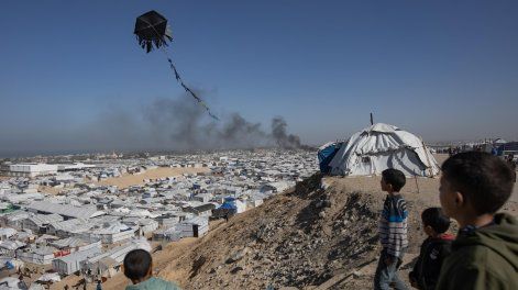 La gente observa cómo se eleva el humo tras un ataque aéreo israelí que tuvo como objetivo el campamento de Ghaith, que alberga a personas desplazadas, en la zona de Al-Mawasi, al oeste de Khan Younis, en el sur de la Franja de Gaza, el 31 de enero de 2026.