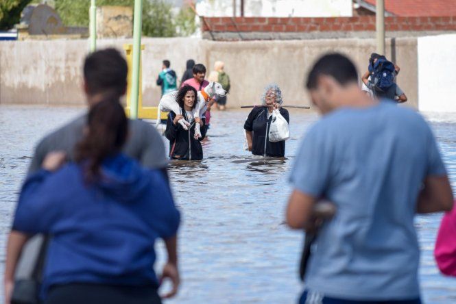 Personas caminando en una inundación este sábado en Bahía Blanca.