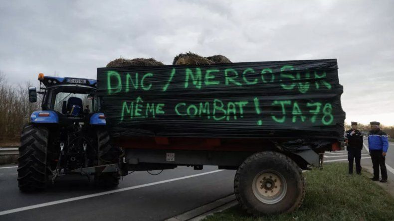 Agricultores de Yvelines bloquearon parcialmente la N12 cerca de París con un tractor y un cartel que decía “DNC / Mercosur, misma lucha” el 16 de diciembre de 2025.