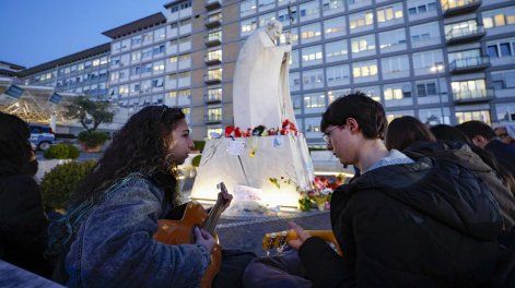 Fieles rezan ante la estatua de Juan Pablo II a la entrada del Hospital Gemelli, donde se encuentra internado el papa Francisco.