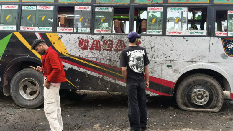 Residentes junto a un autobús dañado en la ciudad india de Poonch, 8 de mayo de 2025